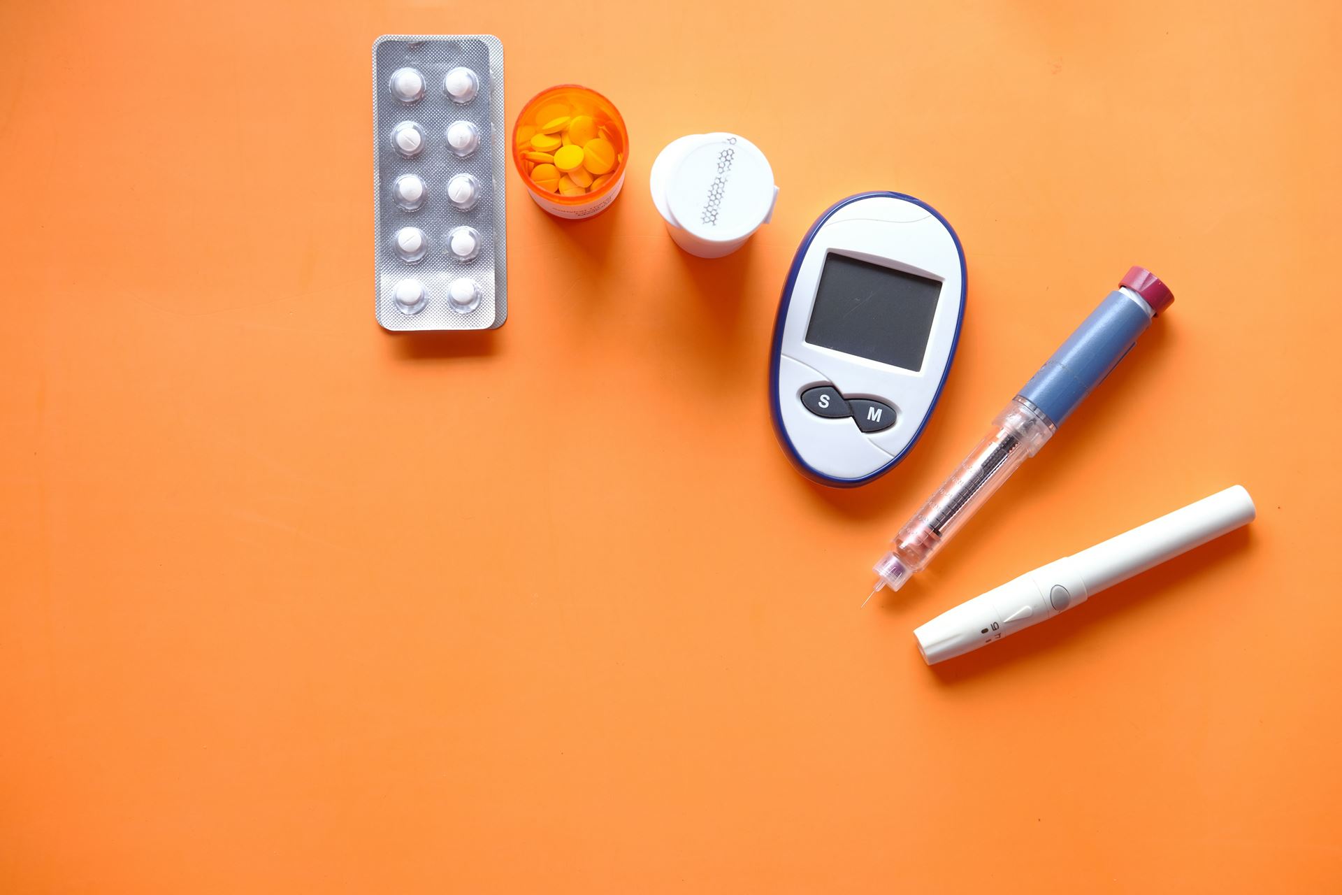 A selection of equipment used by people with diabetes, including a blood sugar monitor, an insulin injector pen and some tablets